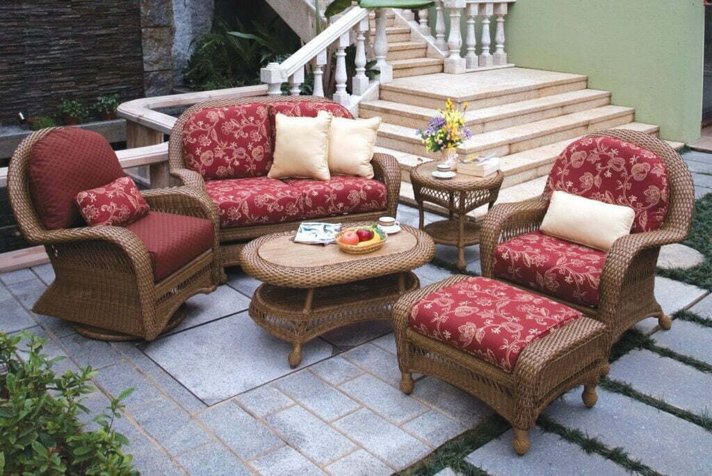 Island Collection wicker loveseat, swivel glider, club chair and ottoman with coffee and end tables on a stone patio