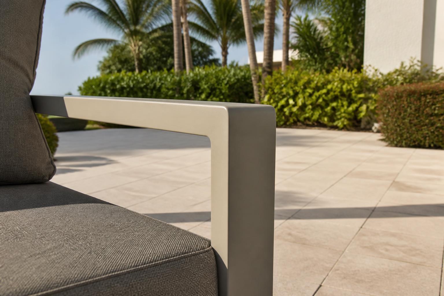 Powder-coated aluminum chair arm in direct sun on an open patio
