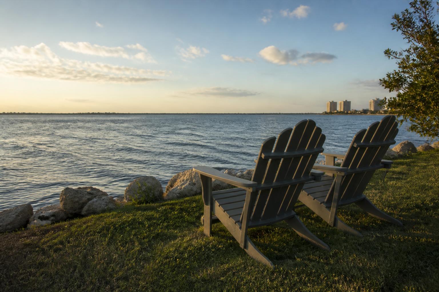 Adirondack chairs on a seawall lawn facing the Intracoastal Waterway