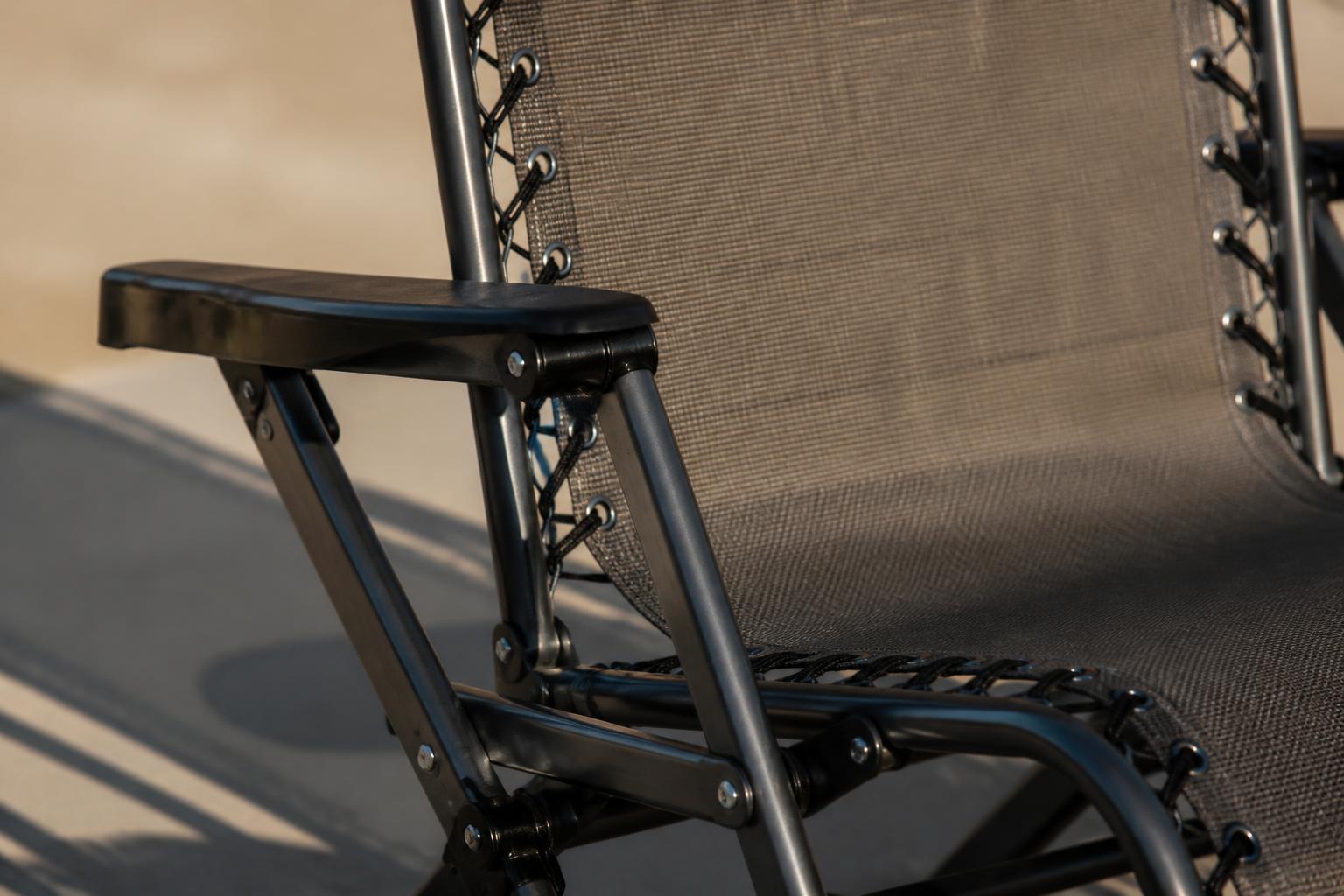 Close-up of a zero-gravity chair's folding aluminum frame and sling fabric