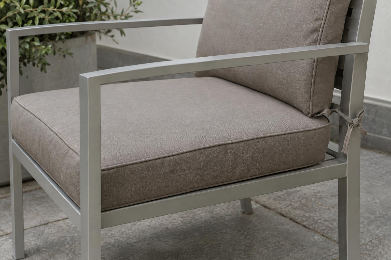 Fitted outdoor chair cushion showing its front edge and rear fabric ties