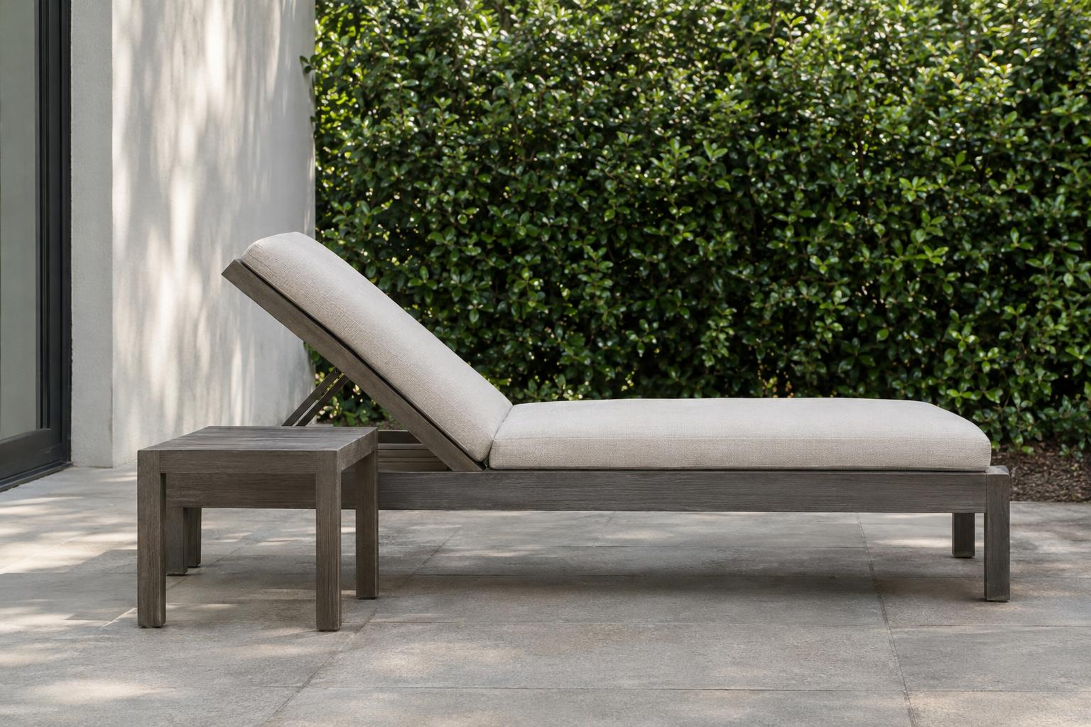 Reclining outdoor chaise with a low side table beside the backrest area